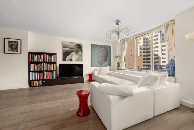 170 E 87th St Unit W8D, New York City, NY 10028 - living room with wood finished floors, baseboards, and a chandelier