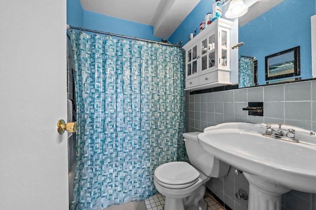 5500 Fieldston Rd Unit 7Ee, New York City, NY 10471 - bathroom featuring tile walls, toilet, curtained shower, a sink, and tile patterned floors