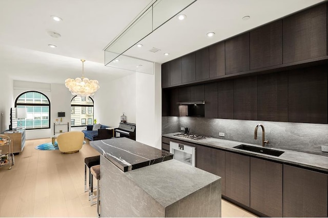 130 William St Unit 10-F, New York City, NY 10038 - kitchen featuring stainless steel gas cooktop, decorative backsplash, a chandelier, modern cabinets, and recessed lighting