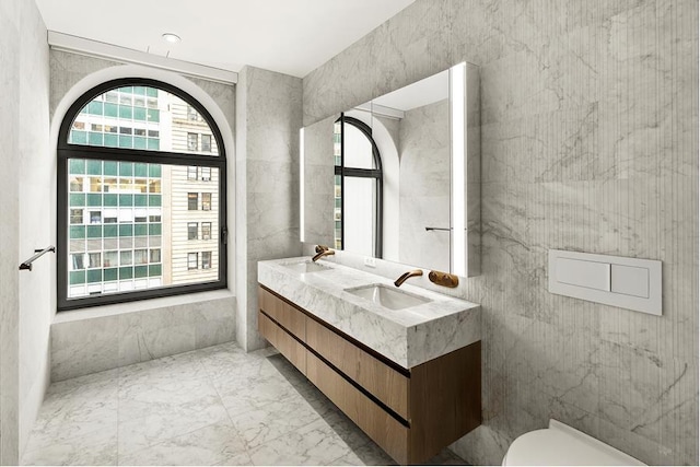 130 William St Unit 10-F, New York City, NY 10038 - bathroom with plenty of natural light, double vanity, and marble finish floors