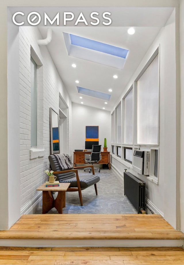 40 W 67th St Unit 1A, New York City, NY 10023 - living room with a skylight, radiator heating unit, cooling unit, and wood finished floors