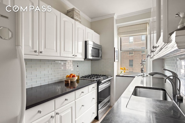 37-28 80th St Unit 32, New York City, NY 11372 - kitchen with appliances with stainless steel finishes, crown molding, decorative backsplash, white cabinets, and dark countertops