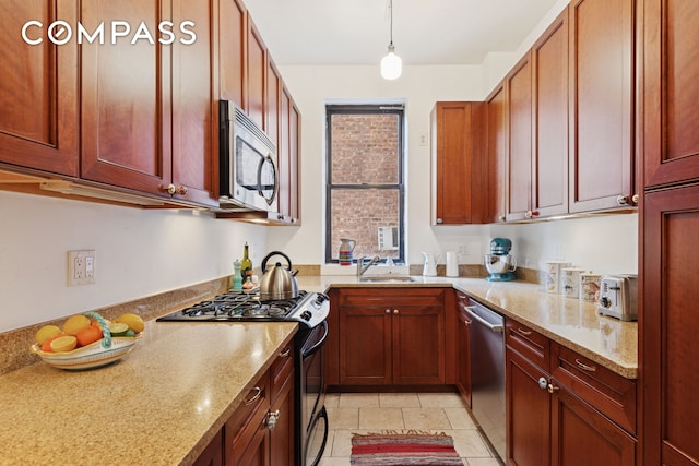 158-18 Riverside Dr W Unit 2M, New York City, NY 10032 - kitchen with appliances with stainless steel finishes, light stone counters, hanging light fixtures, a sink, and reddish brown cabinets