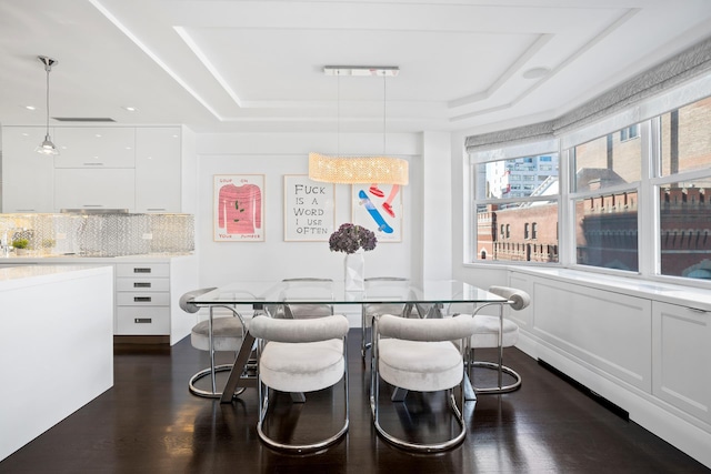 116 E 66th St Unit 9/10C, New York City, NY 10065 - dining space with a tray ceiling and dark wood-style floors