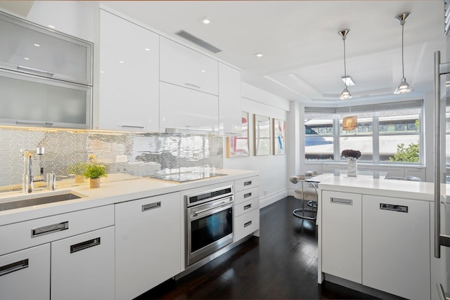 116 E 66th St Unit 9/10C, New York City, NY 10065 - kitchen with oven, dark wood-style floors, a sink, decorative backsplash, and recessed lighting