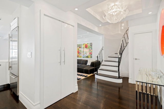 116 E 66th St Unit 9/10C, New York City, NY 10065 - foyer entrance featuring wood finished floors, a chandelier, stairs, recessed lighting, and a tray ceiling