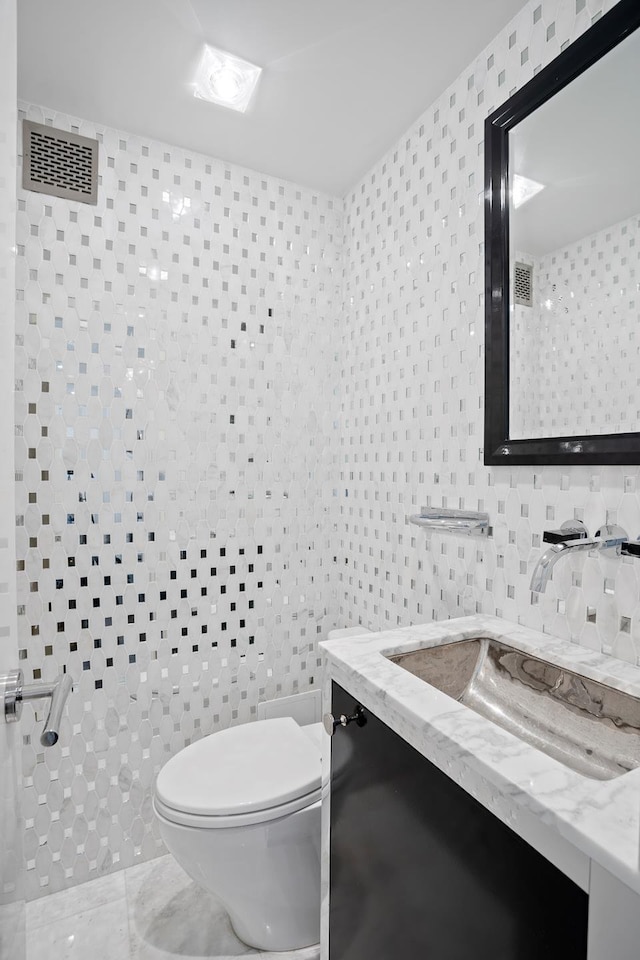 116 E 66th St Unit 9/10C, New York City, NY 10065 - bathroom with toilet, vanity, and tile walls