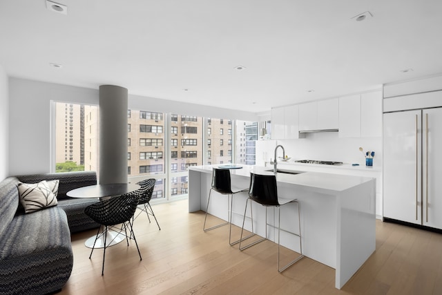 1355 1st Ave Unit 11Fl, New York City, NY 10021 - kitchen featuring a sink, paneled fridge, modern cabinets, gas cooktop, and light wood-type flooring