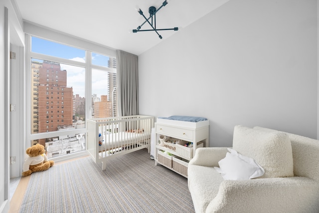 1355 1st Ave Unit 11Fl, New York City, NY 10021 - bedroom featuring a chandelier, a view of city, lofted ceiling, and a crib