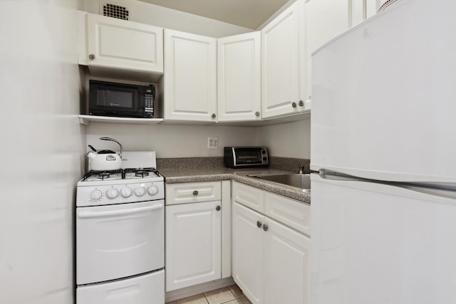 309 E 87th St Unit 6U, New York City, NY 10128 - kitchen with white appliances, white cabinetry, dark countertops, and a sink