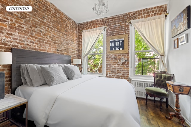 77 Perry St Unit 4C, New York City, NY 10014 - bedroom featuring radiator heating unit, brick wall, and wood finished floors
