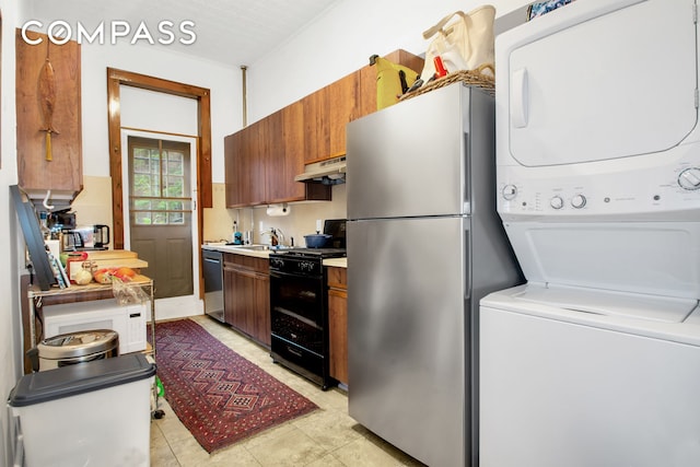 545 10th St, New York City, NY 11215 - kitchen featuring stainless steel appliances, stacked washing machine and dryer, under cabinet range hood, light countertops, and a sink