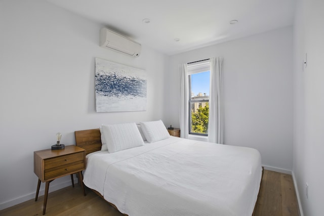 43 Halsey St Unit 4, New York City, NY 11216 - bedroom featuring an AC wall unit, wood finished floors, and baseboards