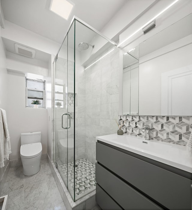 10 W 86th St Unit 15A, New York City, NY 10024 - bathroom featuring toilet, vanity, a stall shower, decorative backsplash, and marble finish floors
