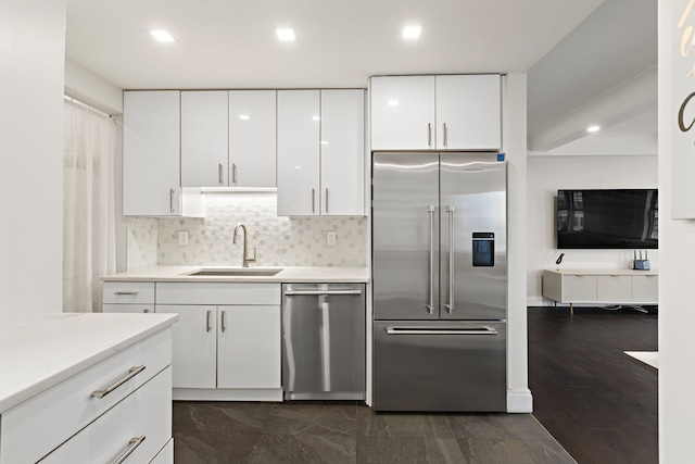 10 W 86th St Unit 15A, New York City, NY 10024 - kitchen with appliances with stainless steel finishes, a sink, white cabinets, tasteful backsplash, and light countertops