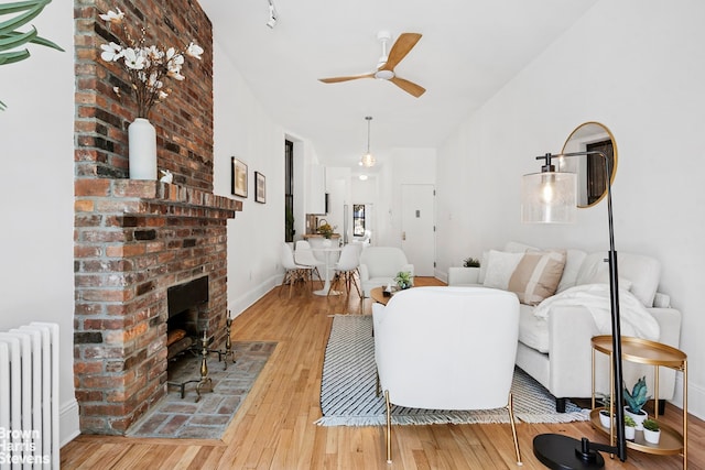 354 Baltic St Unit 2, New York City, NY 11201 - living area with radiator heating unit, a ceiling fan, hardwood / wood-style floors, and a brick fireplace