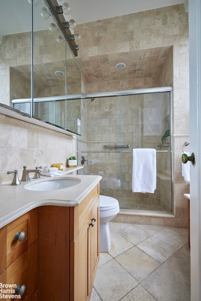 970 Park Ave Unit 8N, New York City, NY 10028 - full bathroom featuring vanity, toilet, tile walls, a shower stall, and decorative backsplash