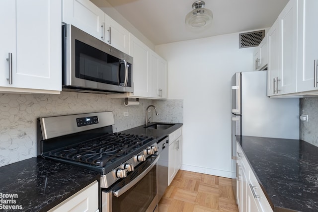 249 E 48th St Unit 3A, New York City, NY 10017 - kitchen featuring appliances with stainless steel finishes, a sink, decorative backsplash, and dark stone counters