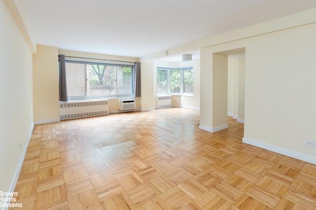 249 E 48th St Unit 3A, New York City, NY 10017 - empty room with radiator heating unit, baseboards, and a wall mounted air conditioner