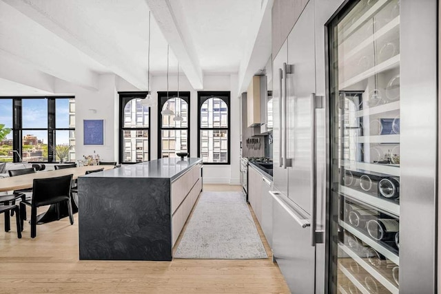 30 Main St Unit 11F, New York City, NY 11201 - kitchen featuring modern cabinets, a kitchen island, beam ceiling, and light wood-style floors
