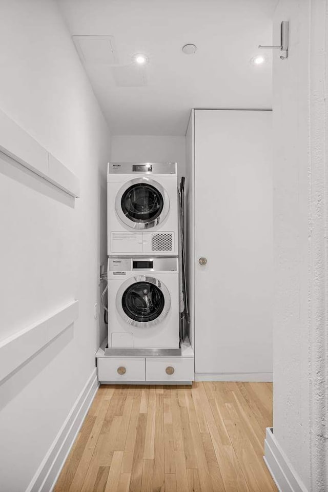 30 Main St Unit 11F, New York City, NY 11201 - washroom featuring stacked washer and clothes dryer, wood finished floors, and baseboards
