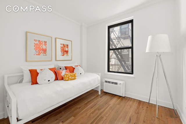 234 E 35th St Unit 3, New York City, NY 10016 - bedroom with crown molding, a wall mounted AC, wood finished floors, and baseboards