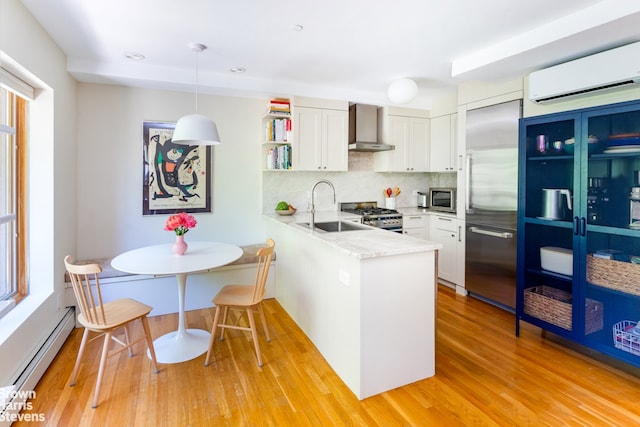 20 Jackson Pl Unit 3, New York City, NY 11215 - kitchen featuring a sink, a baseboard radiator, appliances with stainless steel finishes, wall chimney range hood, and a peninsula