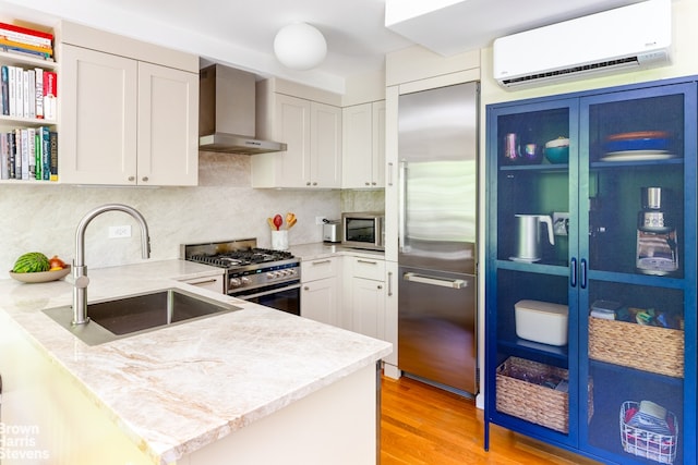 20 Jackson Pl Unit 3Ps2, New York City, NY 11215 - kitchen with wall chimney range hood, stainless steel appliances, a wall unit AC, a sink, and a peninsula