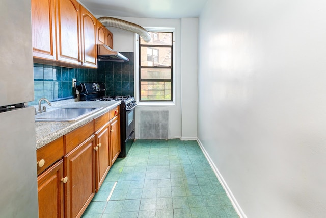 100-25 Queens Blvd Unit 2Aa, New York City, NY 11375 - kitchen with black gas range, freestanding refrigerator, under cabinet range hood, a sink, and brown cabinetry