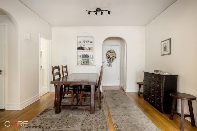 35-15 84th St Unit 4A, New York City, NY 11372 - dining area with arched walkways, wood finished floors, and baseboards