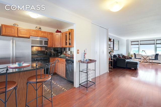 5700 Arlington Ave Unit 16T, New York City, NY 10471 - kitchen with stainless steel appliances, a kitchen bar, open floor plan, a sink, and dark countertops