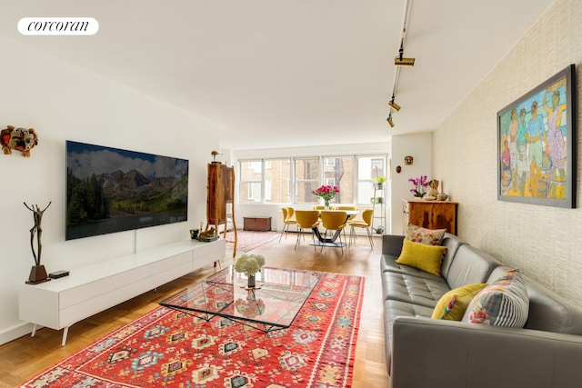 155 E 34th St Unit 8S, New York City, NY 10016 - living area featuring rail lighting, wood finished floors, and wallpapered walls