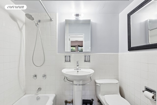 345 E 69th St Unit 2B, New York City, NY 10021 - bathroom with tile walls, tub / shower combination, toilet, a sink, and wainscoting