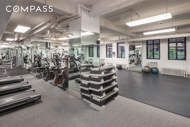320 E 42nd St Unit 516, New York City, NY 10017 - exercise room featuring radiator and a wall mounted air conditioner