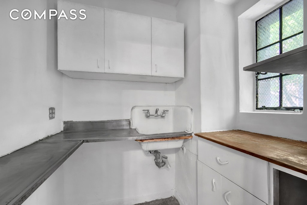 320 E 42nd St Unit 418, New York City, NY 10017 - kitchen with white cabinetry and butcher block countertops