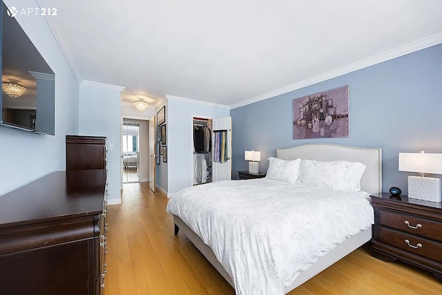 340 E 80th St Unit 20-J, New York City, NY 10075 - bedroom featuring ornamental molding, light wood-style floors, a closet, baseboards, and a spacious closet