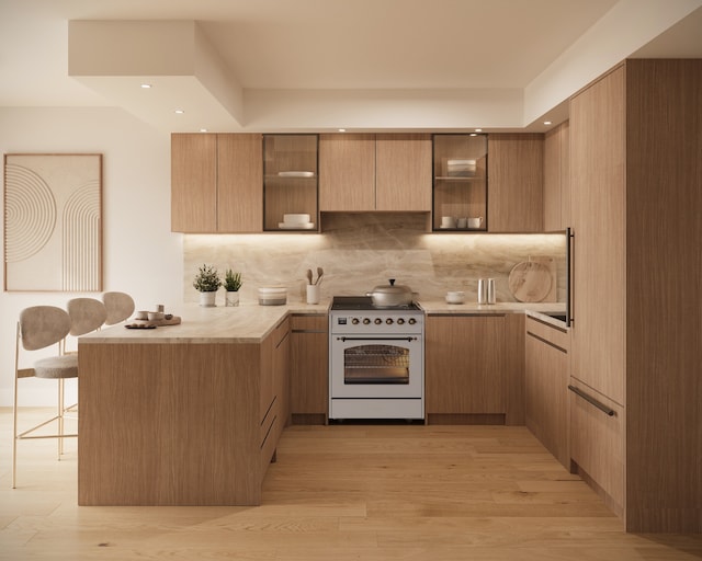 228 13th St Unit 203, New York City, NY 11215 - kitchen with white electric stove, a peninsula, modern cabinets, a kitchen breakfast bar, and light countertops