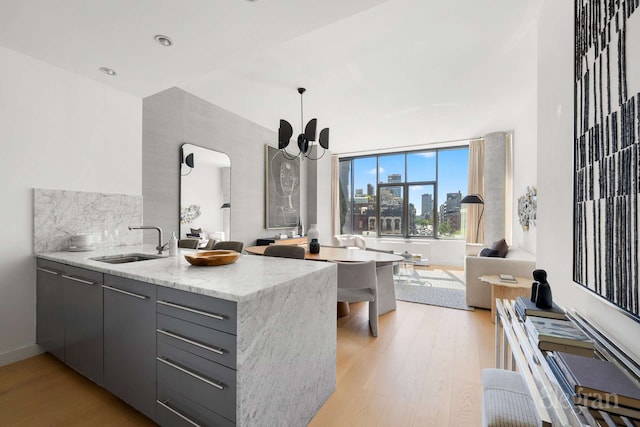 210 Lafayette St Unit 5A, New York City, NY 10012 - kitchen featuring open floor plan, a sink, light wood finished floors, a peninsula, and modern cabinets