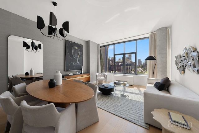 210 Lafayette St Unit 5A, New York City, NY 10012 - dining area with light wood-style flooring, a chandelier, and a skyline view