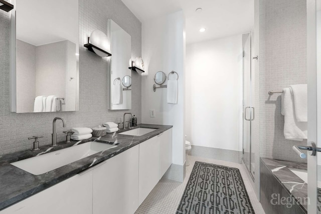210 Lafayette St Unit 5A, New York City, NY 10012 - full bathroom with toilet, a shower stall, double vanity, tile patterned flooring, and recessed lighting