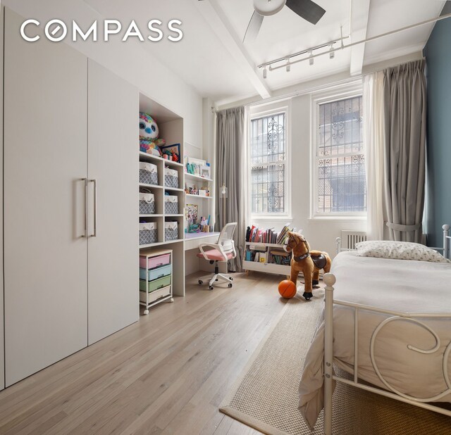 28 W 38th St Unit 6E, New York City, NY 10018 - bedroom featuring wood finished floors, track lighting, and beamed ceiling