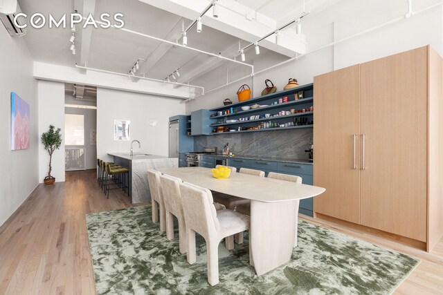 28 W 38th St Unit 6E, New York City, NY 10018 - kitchen featuring premium appliances, open shelves, a sink, modern cabinets, and backsplash