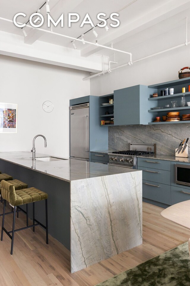 28 W 38th St Unit 6E, New York City, NY 10018 - dining space with rail lighting, light wood-style flooring, and bar with sink