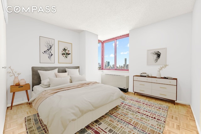 4-74 48th Ave Unit Ph2B, New York City, NY 11109 - bedroom with a textured ceiling, a view of skyline, and baseboards