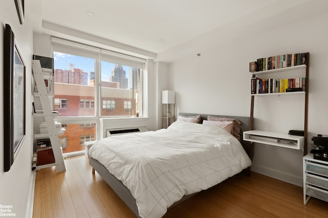 505 W 47th St Unit Ph2S, New York City, NY 10036 - bedroom with wood finished floors and a view of city