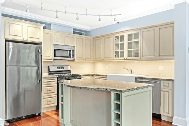18 Morningside Ave Unit 3, New York City, NY 10026 - kitchen with appliances with stainless steel finishes, cream cabinetry, a sink, light stone counters, and ornamental molding