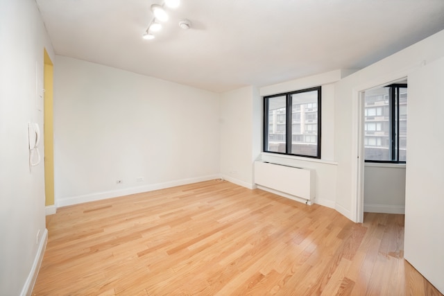 233 E 86th St Unit 4A, New York City, NY 10028 - unfurnished room featuring light wood finished floors, radiator heating unit, and a smoke detector