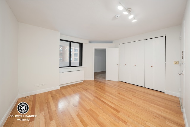 233 E 86th St Unit 4A, New York City, NY 10028 - unfurnished bedroom featuring light wood-style floors, baseboards, and a closet