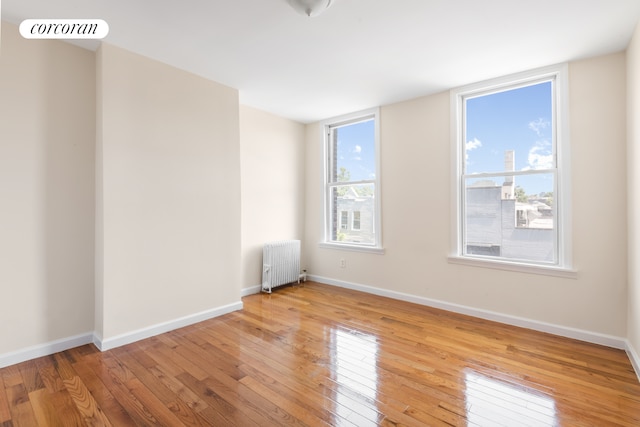 238 26th St, New York City, NY 11232 - unfurnished room with radiator, wood-type flooring, and baseboards
