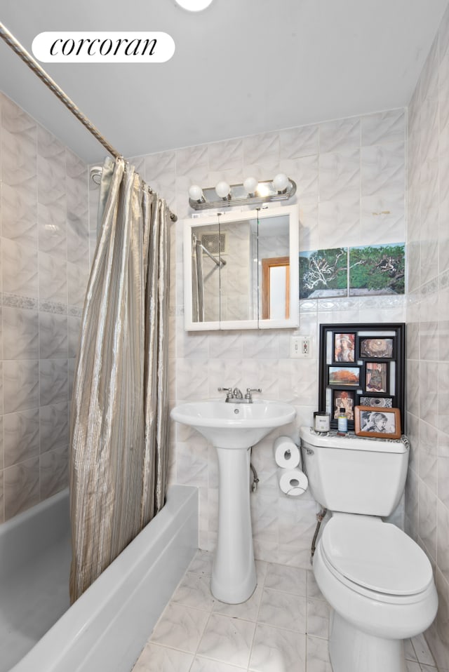 238 26th St, New York City, NY 11232 - full bathroom with tile walls, shower / tub combo, toilet, and marble finish floors
